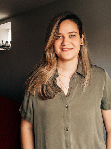 Retrato da Bianca, com um sorriso, olhando para câmera.