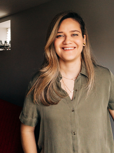 Retrato da Bianca, com um grande sorriso, olhando para câmera.
