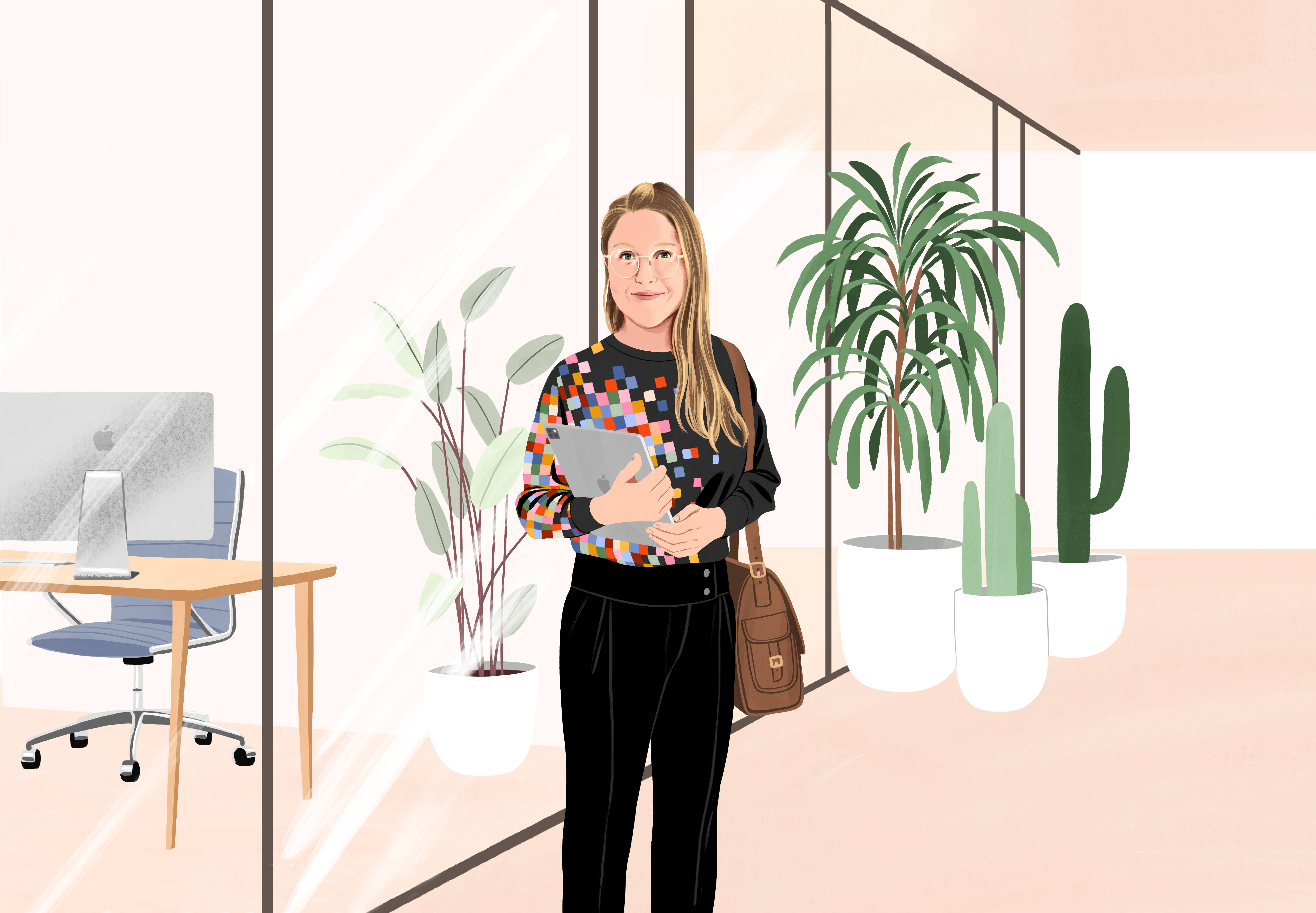 Manuela debout et souriant dans le hall d’un bureau. Elle a un sac à l’épaule et tient un iPad. Elle porte un pantalon et un pull noirs avec un motif de pixels colorés sur un côté.