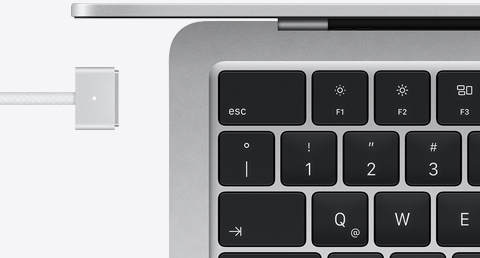 MacBook Air color plata con cable de carga MagSafe del mismo color