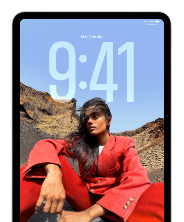 Un iPad muestra la pantalla bloqueada con grandes números de la hora que aparecen detrás de la foto de una persona sentada