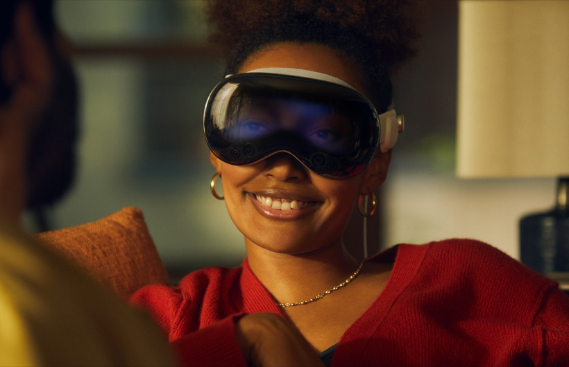 一個人戴著 Apple Vision Pro，透過裝置正面的玻璃外觀可看到雙眼