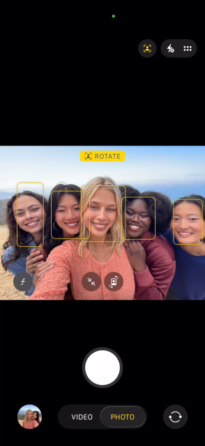 	iPhone 17 Pro screen showing Center Stage for photos feature and how to take a selfie of a group of people, with their faces highlighted