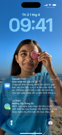 Năm phiên bản iPhone, mỗi phiên bản hơi xếp chồng lên phiên bản bên cạnh, màn hình ngoài cùng bên trái hiển thị cuộc trò chuyện với nền trong Tin Nhắn, màn hình thứ hai bên trái hiển thị Màn Hình Chính với các biểu tượng ứng dụng đầy màu sắc, phiên bản ở giữa hiển thị Màn Hình Khóa với ảnh, các chữ số cho biết thời gian theo phong cách Liquid Glass, hai thông báo xuất hiện ở cuối màn hình, phiên bản thứ hai bên phải hiển thị các biểu tượng ứng dụng theo phong cách Liquid Glass trong suốt, phiên bản ở ngoài cùng bên phải hiển thị trình phát nhạc theo phong cách Liquid Glass